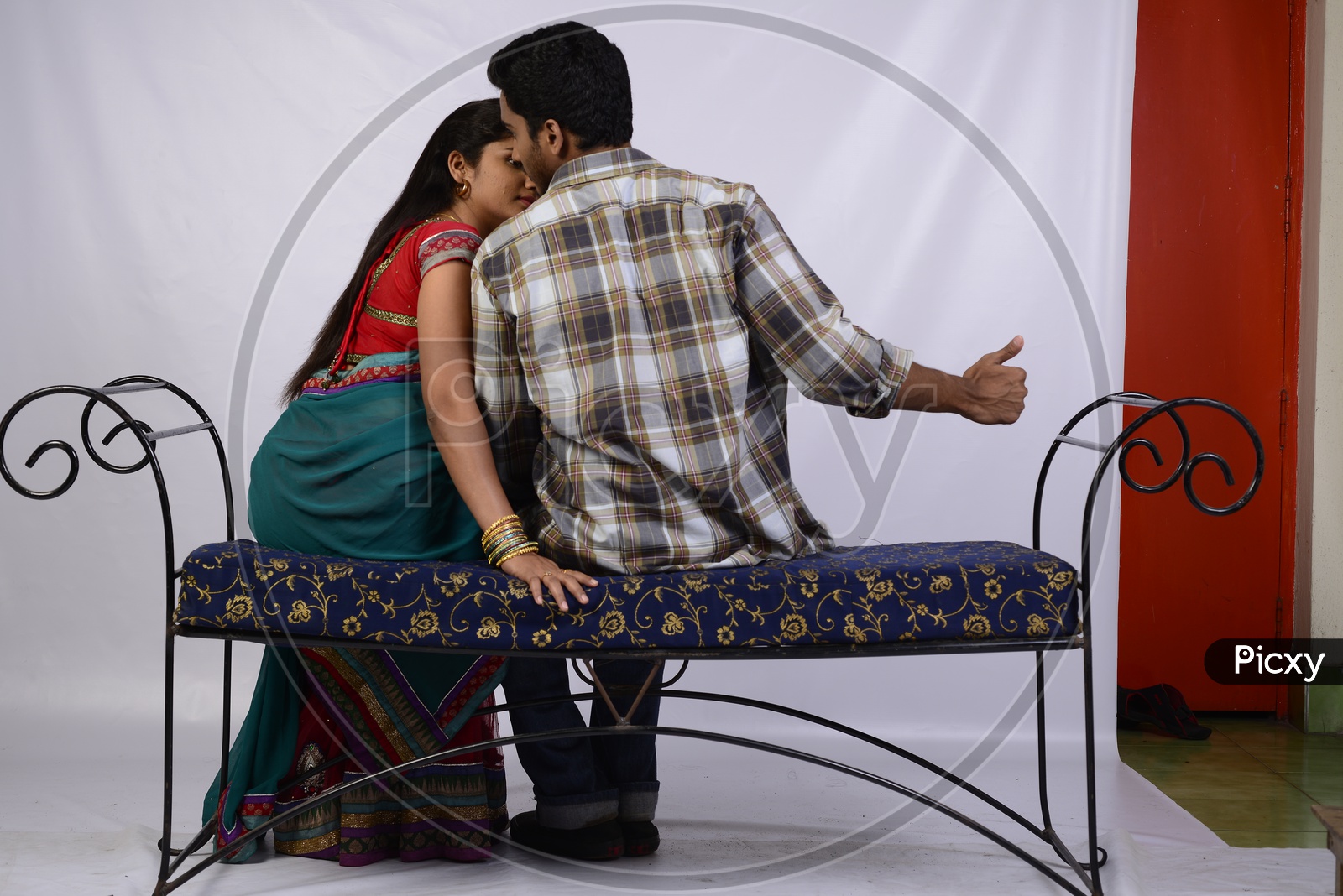 Image of A young Indian Couple Kissing by Sitting On a Sofa on an  Isolated-YM129417-Picxy