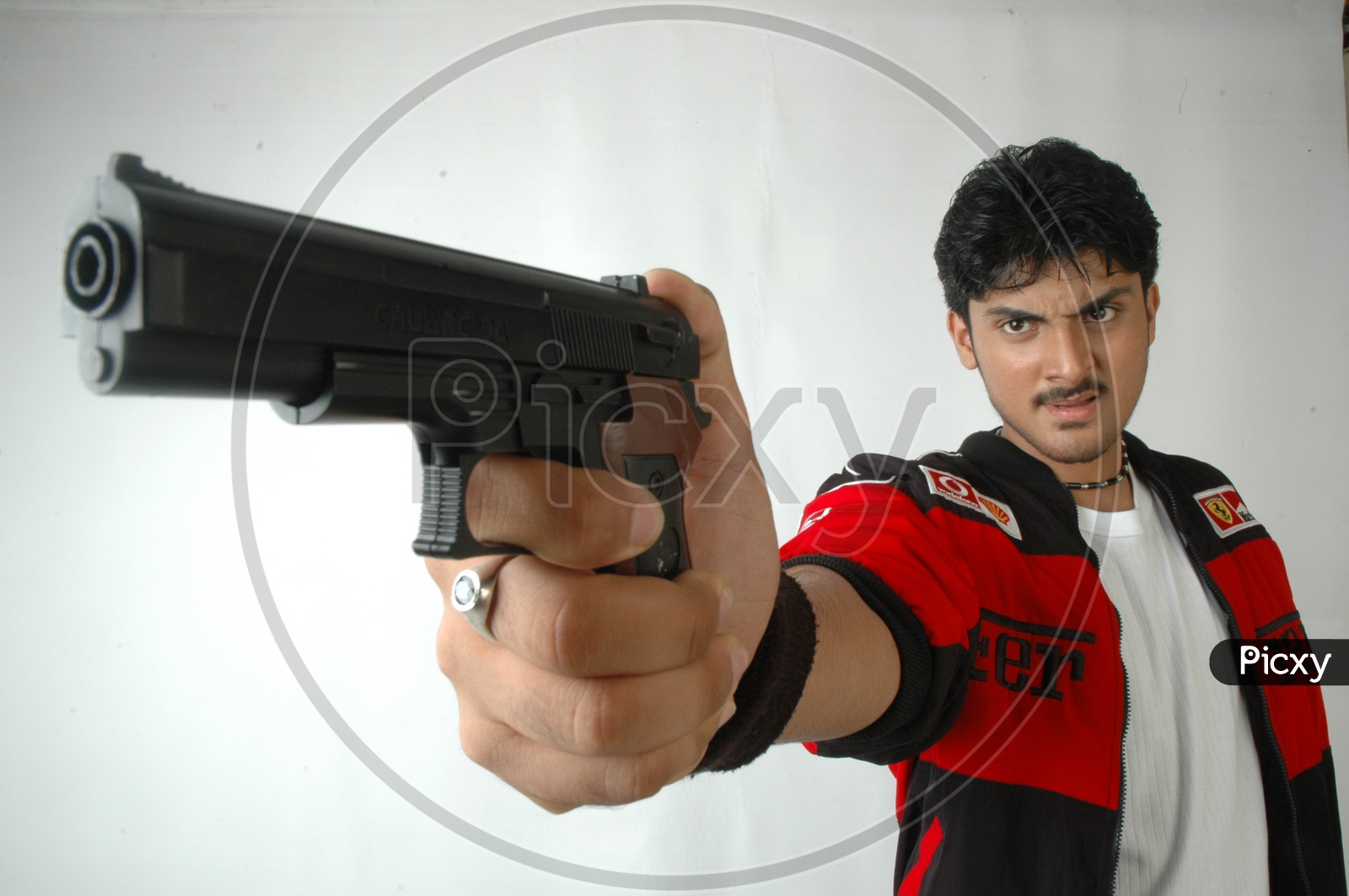 A Young Indian Man Holding Gun or Pistol  And  Posing  On an Isolated White Background