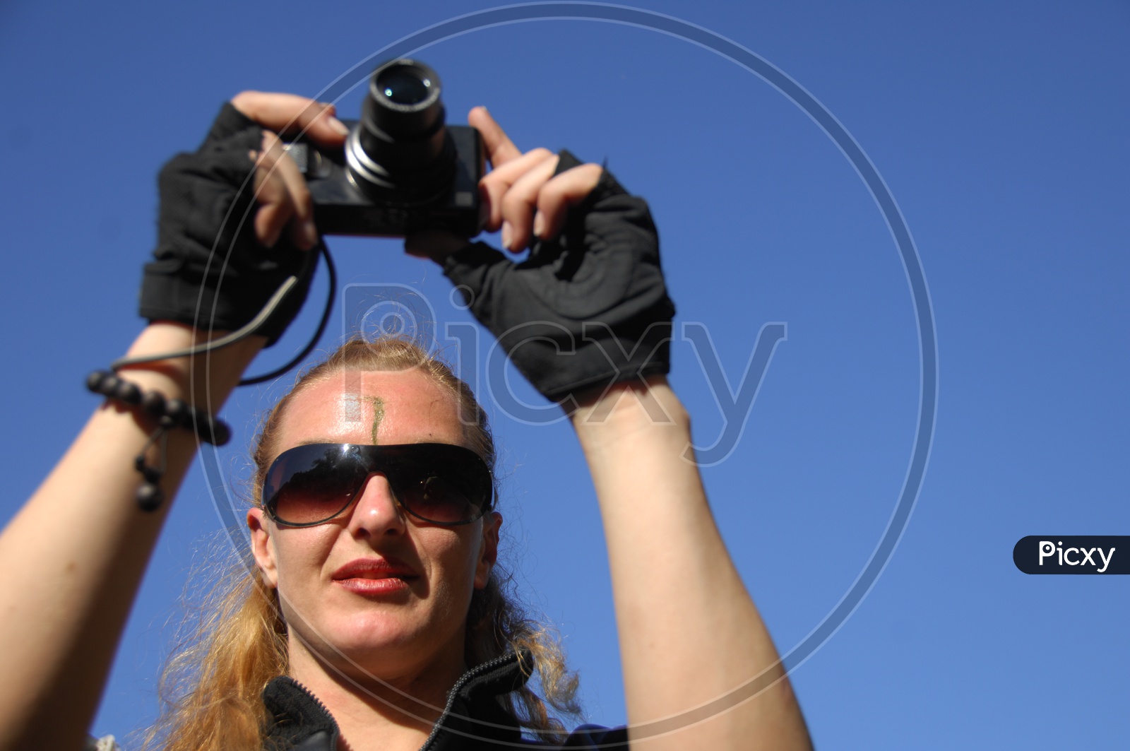 A woman Clicking Pictures  in a Point and Shoot  Camera