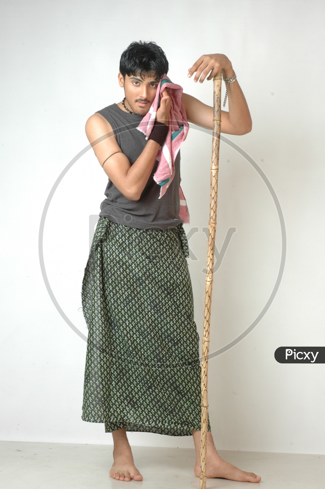 Image of An Indian Man In Traditional Rural Man Attire Holding Wooden Stick  in Hand and Posing On an Isolated White Background-SJ699692-Picxy