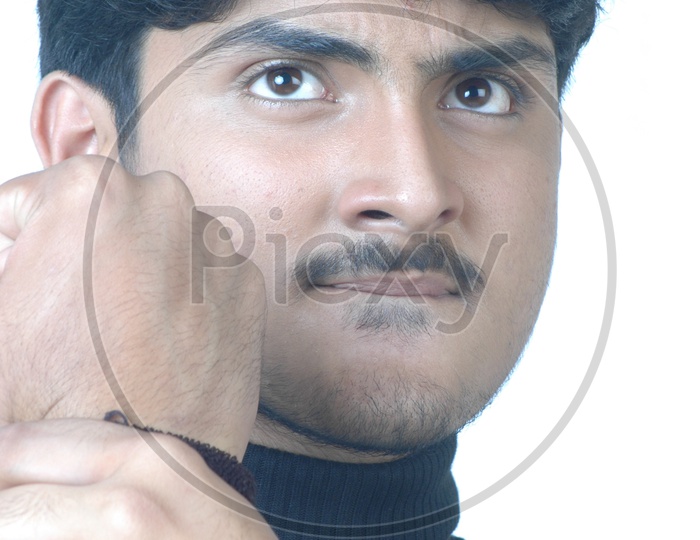 Portrait Of a Angry Indian Young Man  With His Fist Tripping  For Fight  And With a Expression On an Isolated White Background