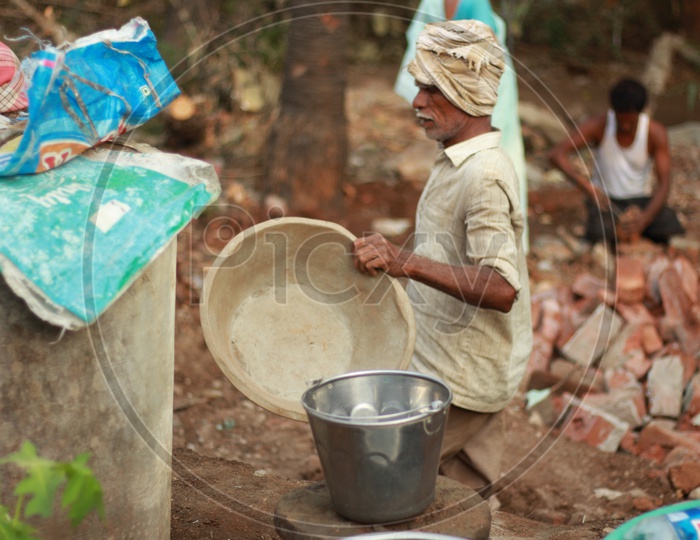 Indian Man holding a construction Ghamela