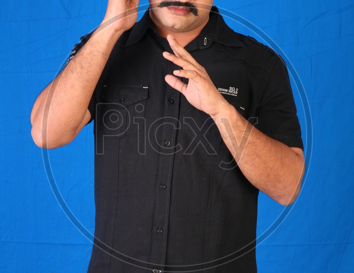 An Indian Man Speaking In a Mobile Phone On an Isolated Blue Background
