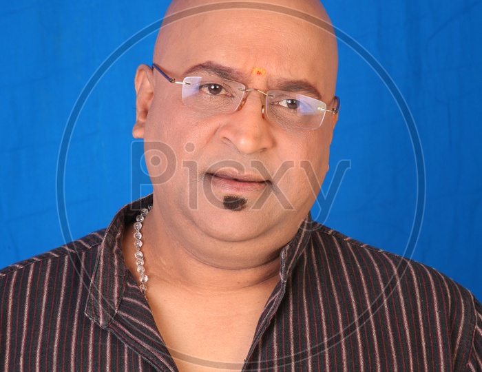 Portrait Of a Indian man Or Tollywood Movie Character Artist In Casual Wear On an Isolated Blue  Background