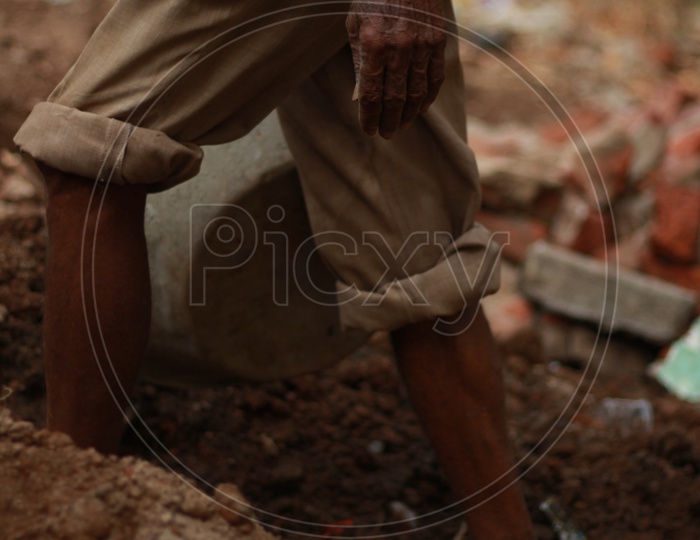 Indian Man with his pants rolled up during the work