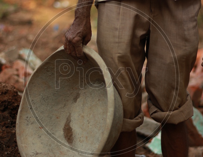 Indian Man holding a construction Ghamela