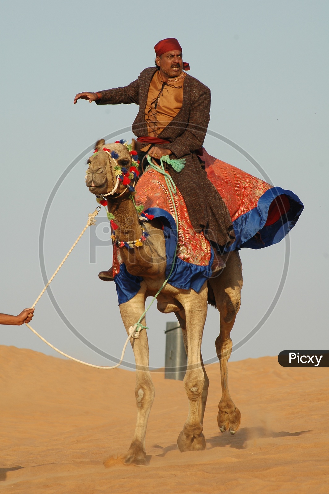 A Desert Man Riding a Camel In Desert
