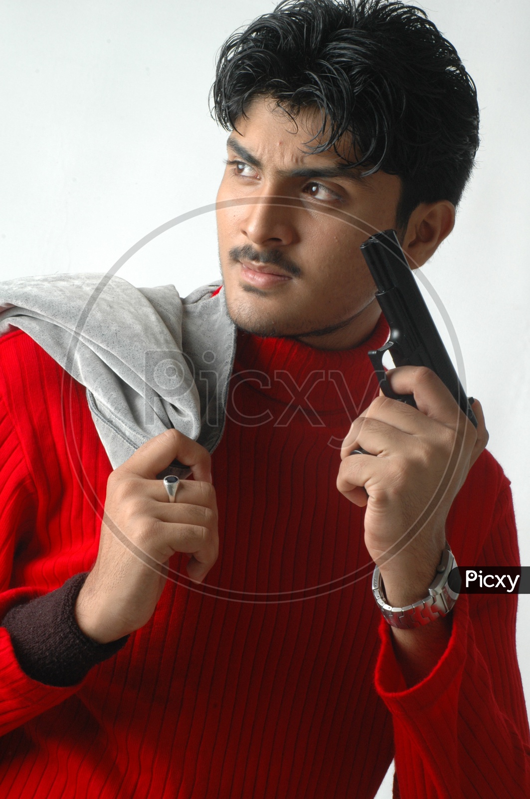 A Young Indian Man Holding Gun  And  Posing  On an Isolated White Background