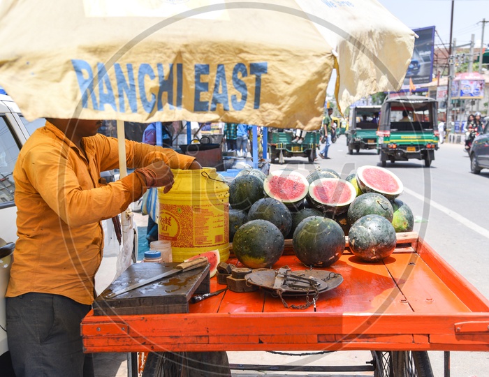 A Vendor Cutting The  Watermelon Pieces  at a Street Vendor Stall On Road Side in Ranchi