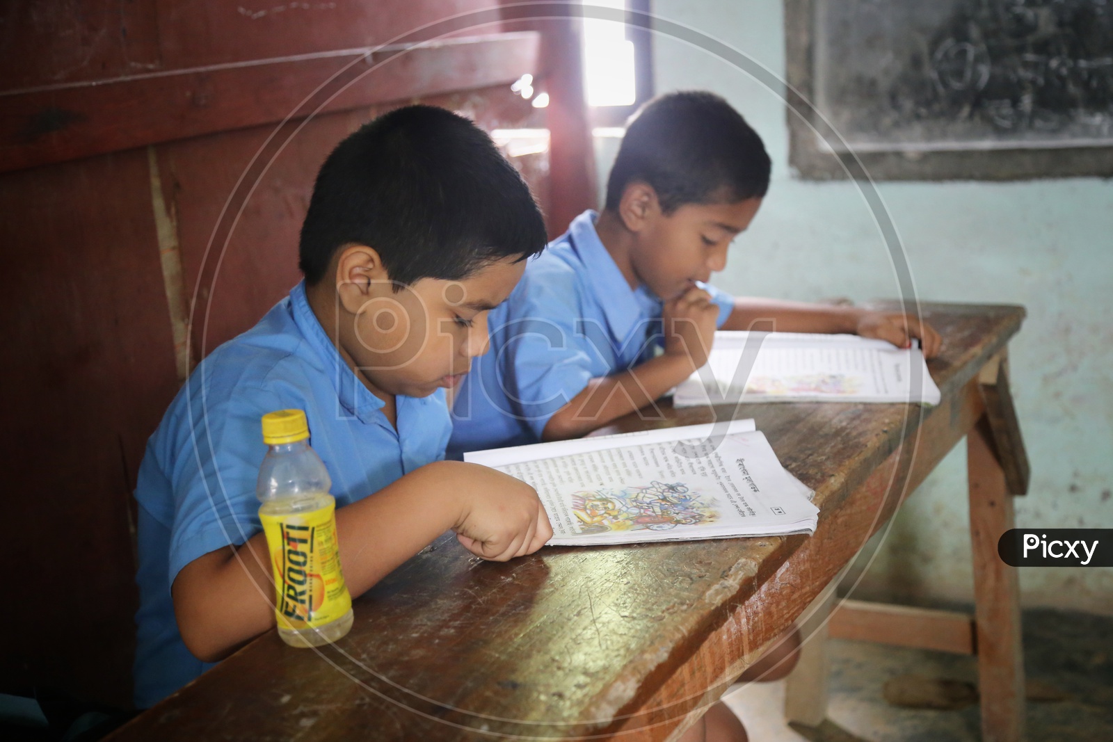 School Children or School Students In Uniforms With Books  Infront Of Them in A Classroom