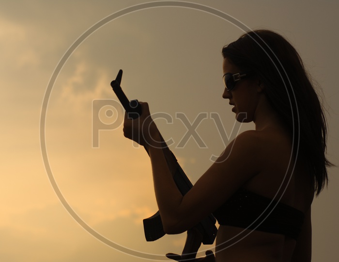 A Woman  Holding a Gun In Hand For a Movie Shoot