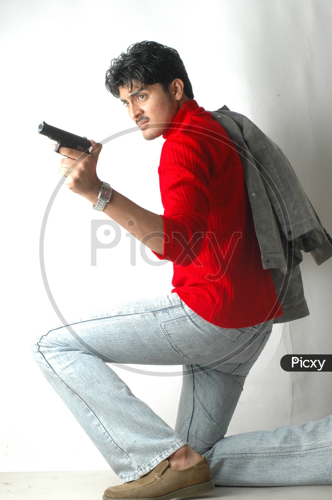 Image of A Young Indian Man Holding Gun or Pistol And Posing On an Isolated  White Background-JN457211-Picxy