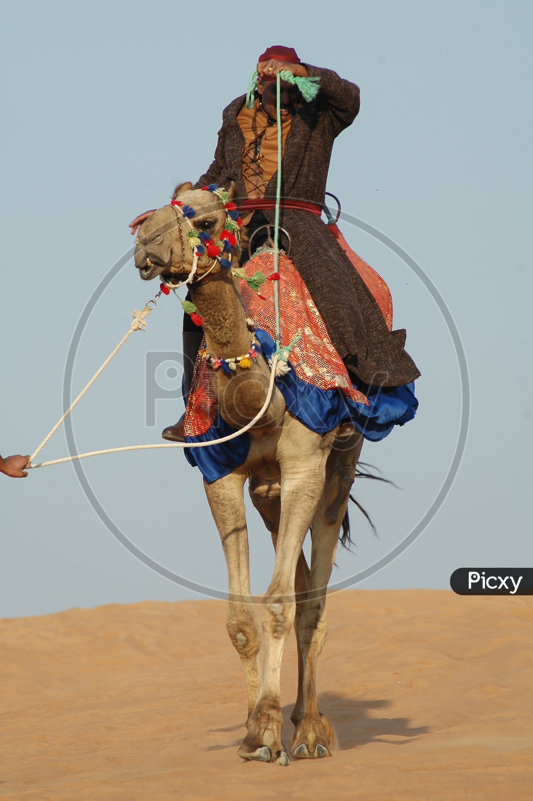 A Desert Man Riding a Camel In Desert