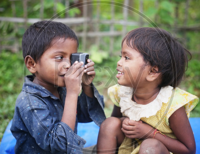 Indian Rural Village Children ( Siblings )  Having Fun With A GoPro Action Camera With a  Smiles On Their  Faces