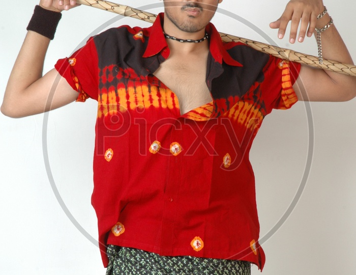 An Indian  Man  In Traditional Rural Man Attire  Holding  Wooden Stick in Hand  and Posing On an Isolated White Background