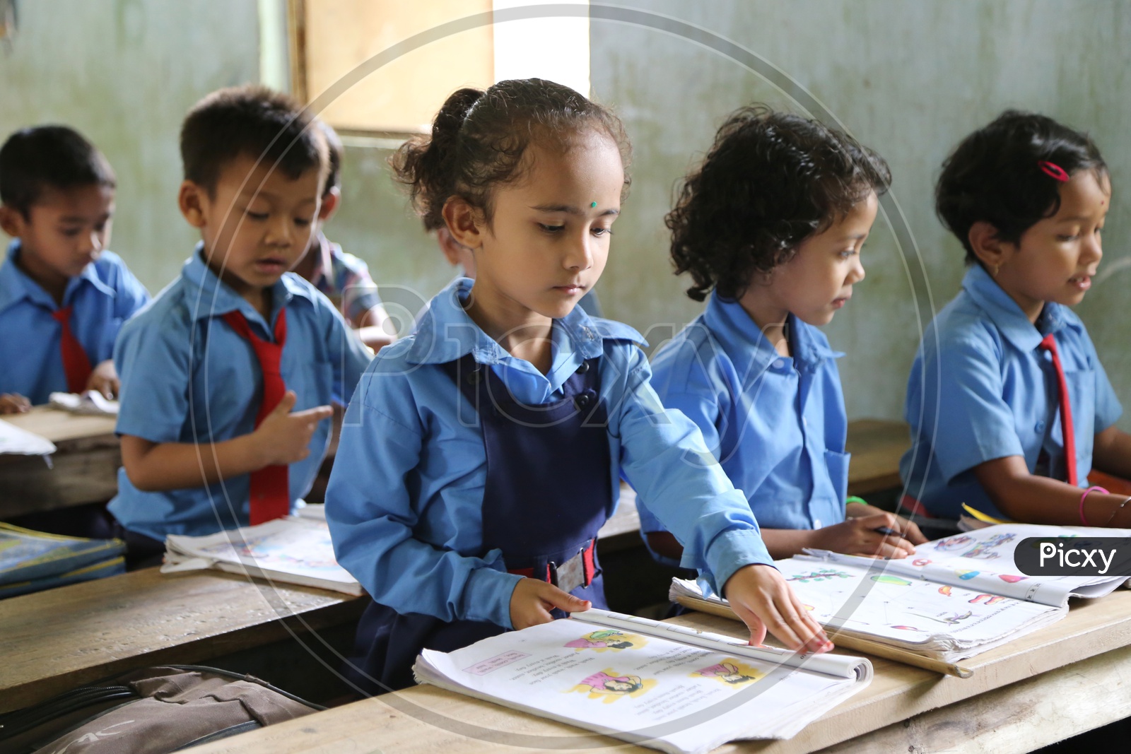 School Children or School Students In Uniforms With Books  Infront Of Them in A Classroom