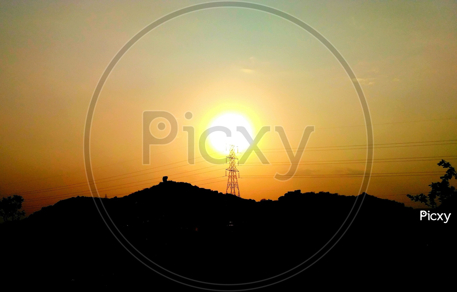 Silhouette Of High Tension Electricity Poles Over Sunset Sky Background