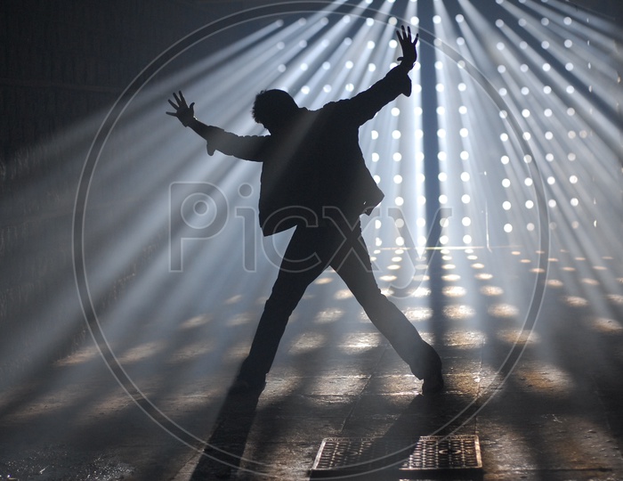 Silhouette Of a Man In an Indoor Room Making a Dance Postures  With Sun Rays Falling On Him