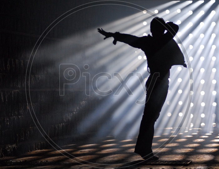 Silhouette Of a Man In an Indoor Room Making a Dance Postures  With Sun Rays Falling On Him