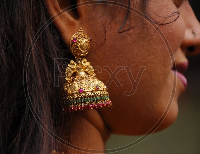 A Beautiful Young traditional Woman Wearing An elegant Jewellery or Ear Rings , Closeup