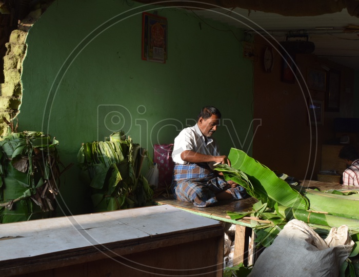 A Vendor  Slicing Banana Leaf In KR Market