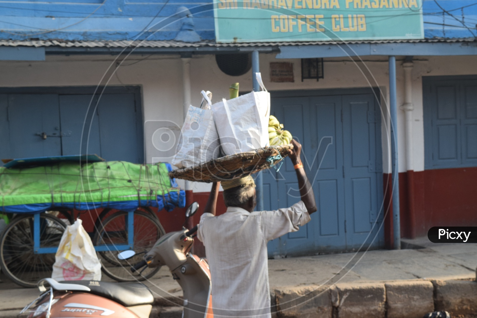 A Street Vendor Carrying Bananas In a Basket On His Over Head In  KR Market