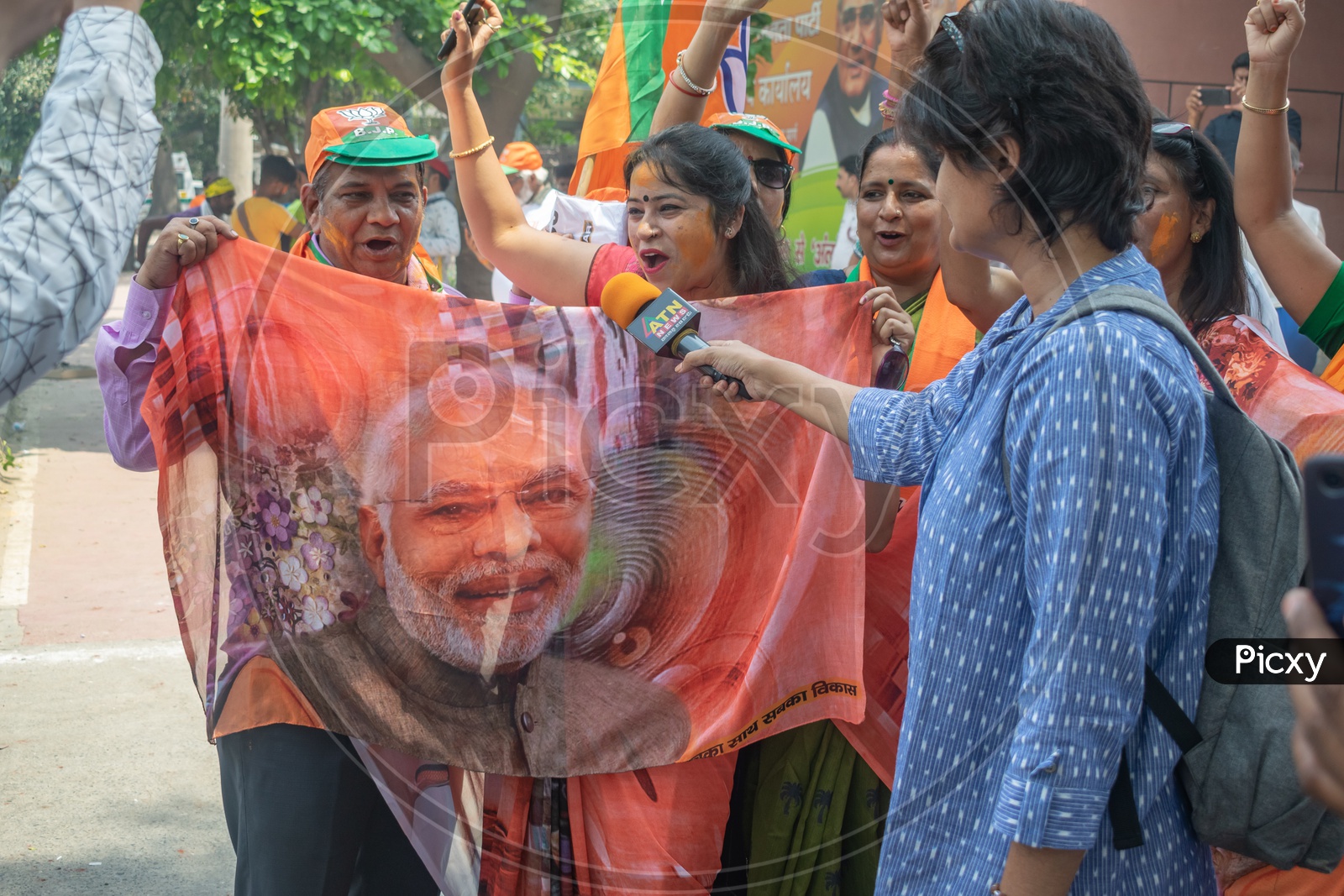 Women wearing sarees that have a picture of Narendra Modi printed on it.