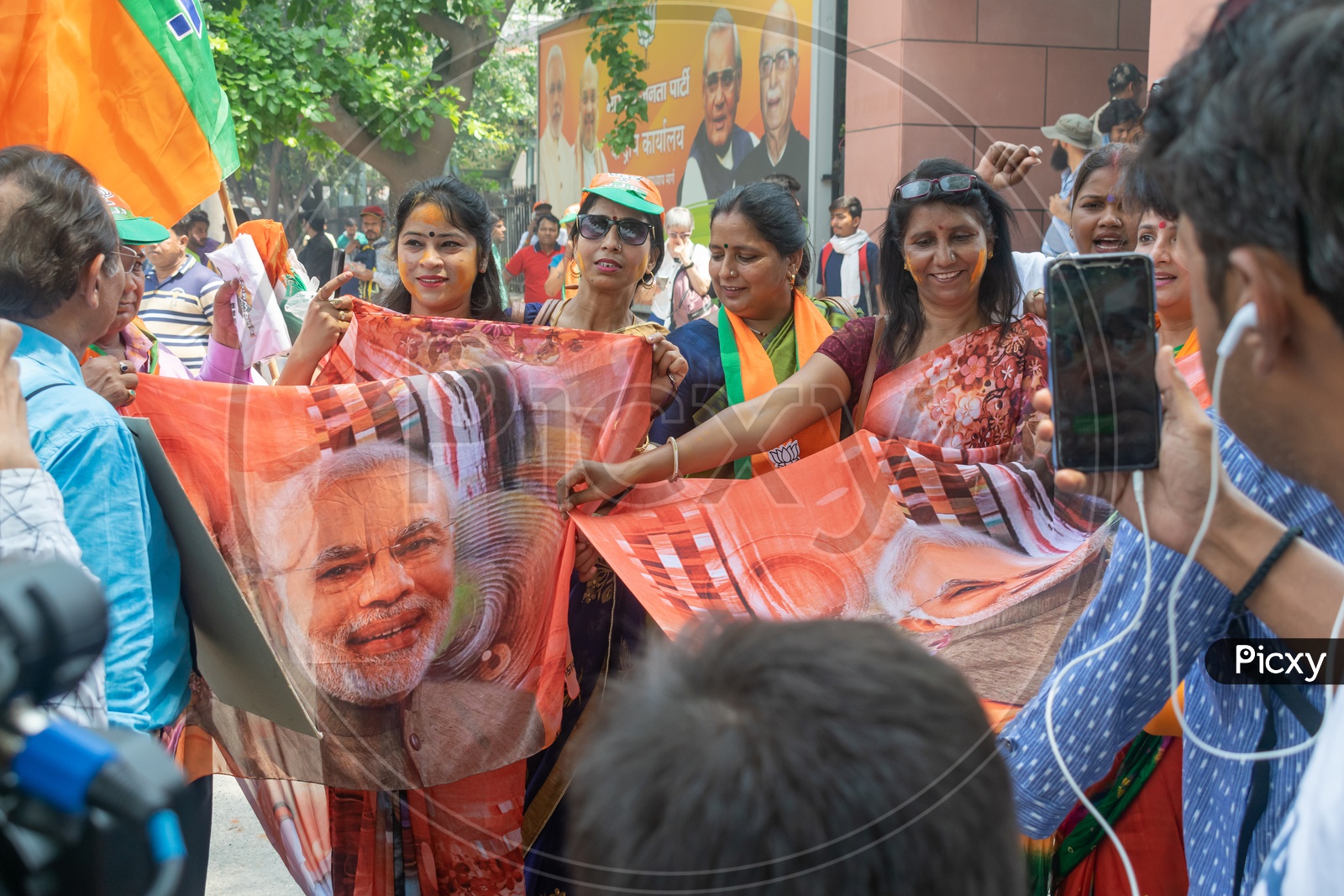 Women wearing sarees that have a picture of Narendra Modi printed on it.