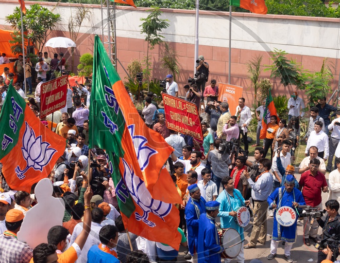 People holding Bhartiya Janta Party(BJP) flags and a band playing drums