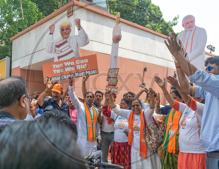 People holding hoardings of current prime minister Narendra Modi and shouting his name.