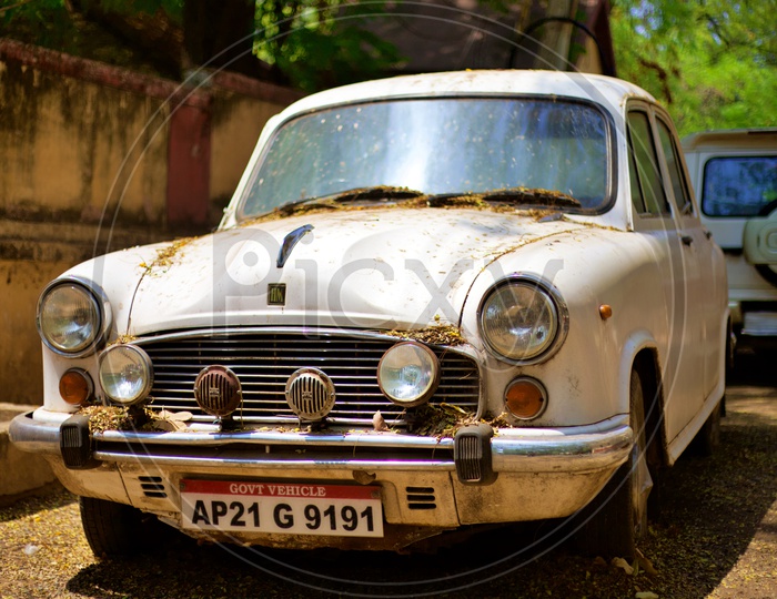 An old Ambassador car covered in dust.