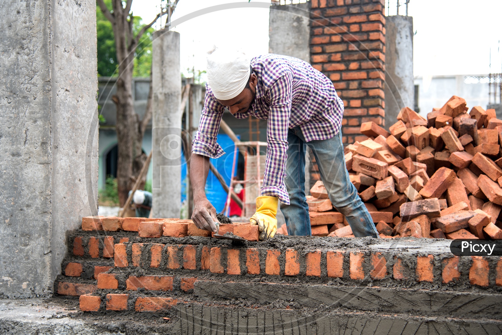 Indian Rural Construction Workers Working Developing a Site By  Cement And Bricks In Hands