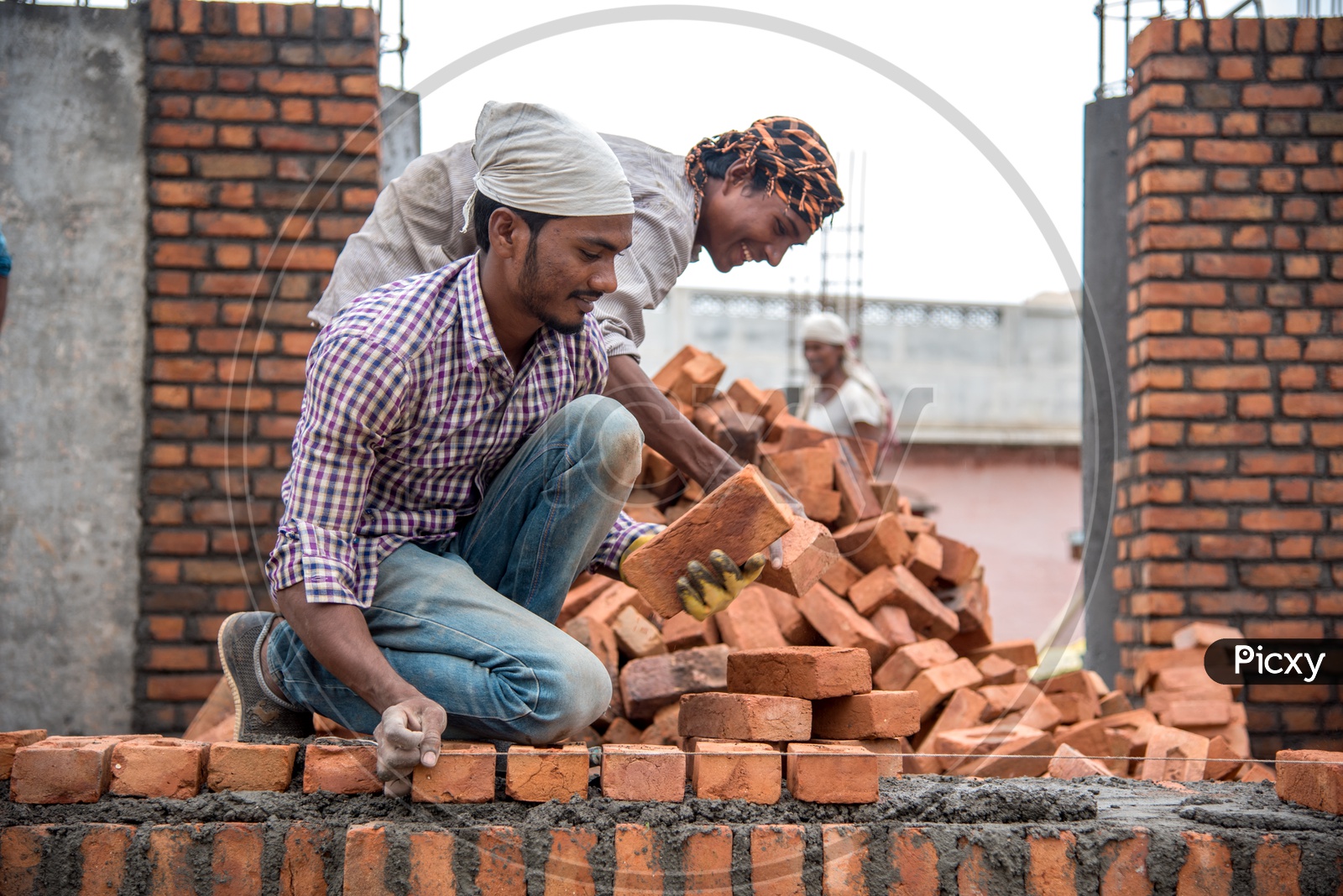 Indian Rural Construction Workers Working Developing a Site By  Cement And Bricks In Hands