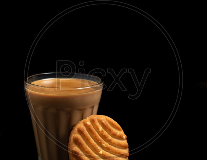 Aromatic beverage Tea/chai   and Good-day biscuits placed on black background.
