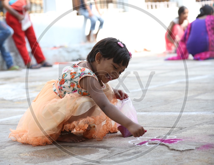 child participate Competition of Rangoli Designs during sankrathi festival