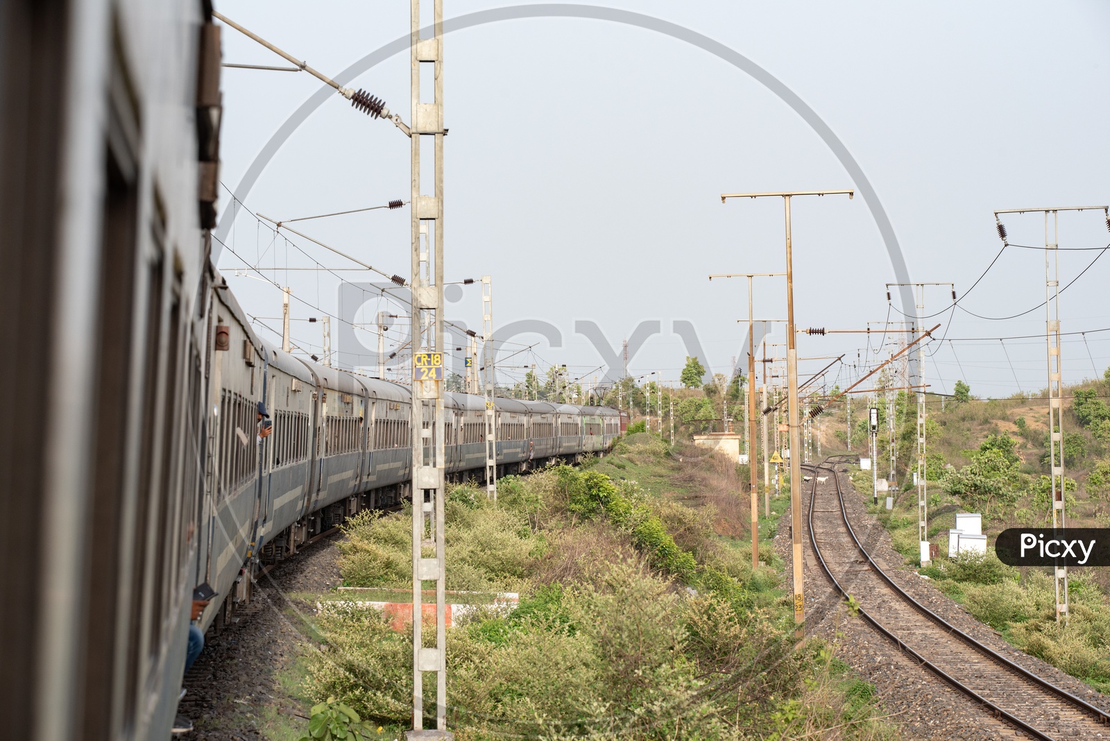 Indian Railways train On Track With a View Of Electricity Poles And Adjacent track