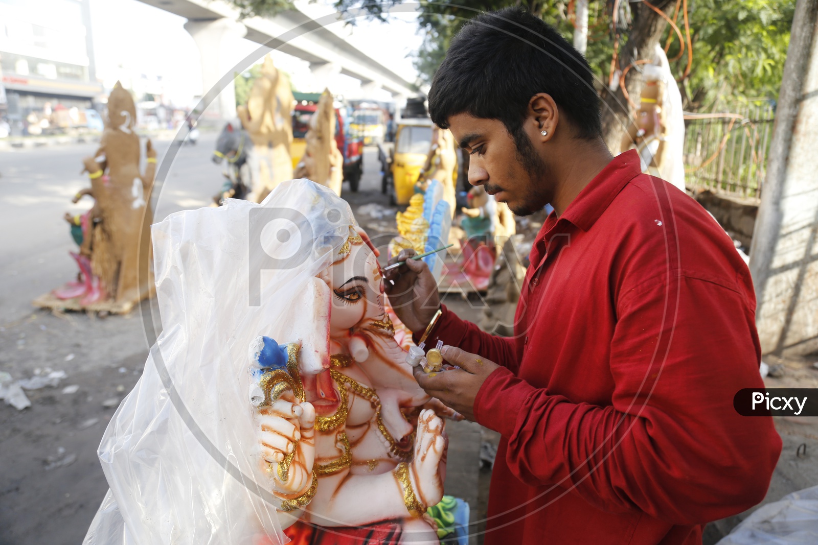boy lends a finishing touch to his eco-friendly Ganesh idol.