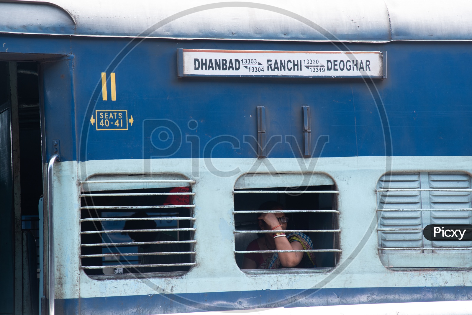 A Woman Passenger Sitting  at a Window Seat in a Indian Railway  train