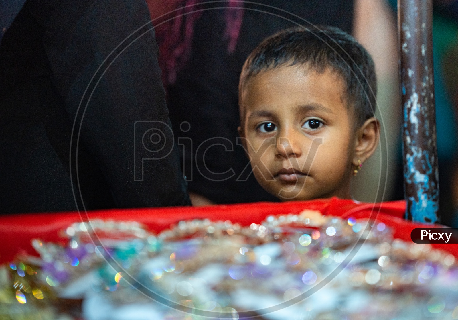 A Small Girl At a Street Vendor Stall Or  Imitation jewellery  Around Charminar Streets  During Ramadan or ramzan Season