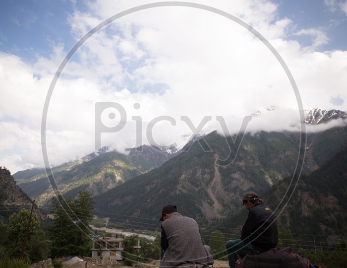 Tourists Or Local People Enjoying The Valley Views With Snow Capped Mountains And Hills