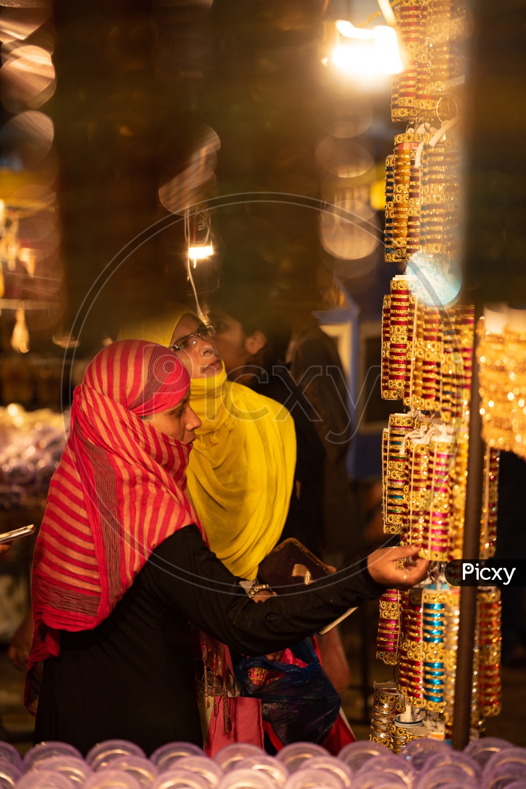 A Young Muslim Woman In Bhurkha   Shopping  Bangles  in a  Vendor Stall Around Charminar  During  Ramadan or Ramzan Season