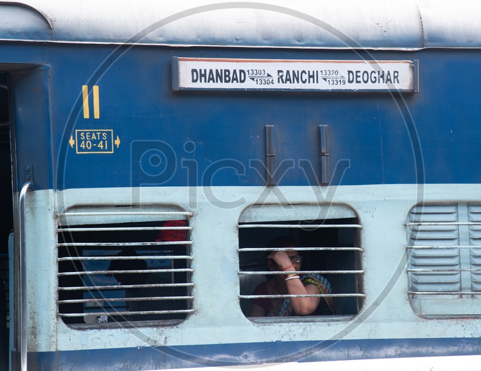 A Woman Passenger Sitting  at a Window Seat in a Indian Railway  train