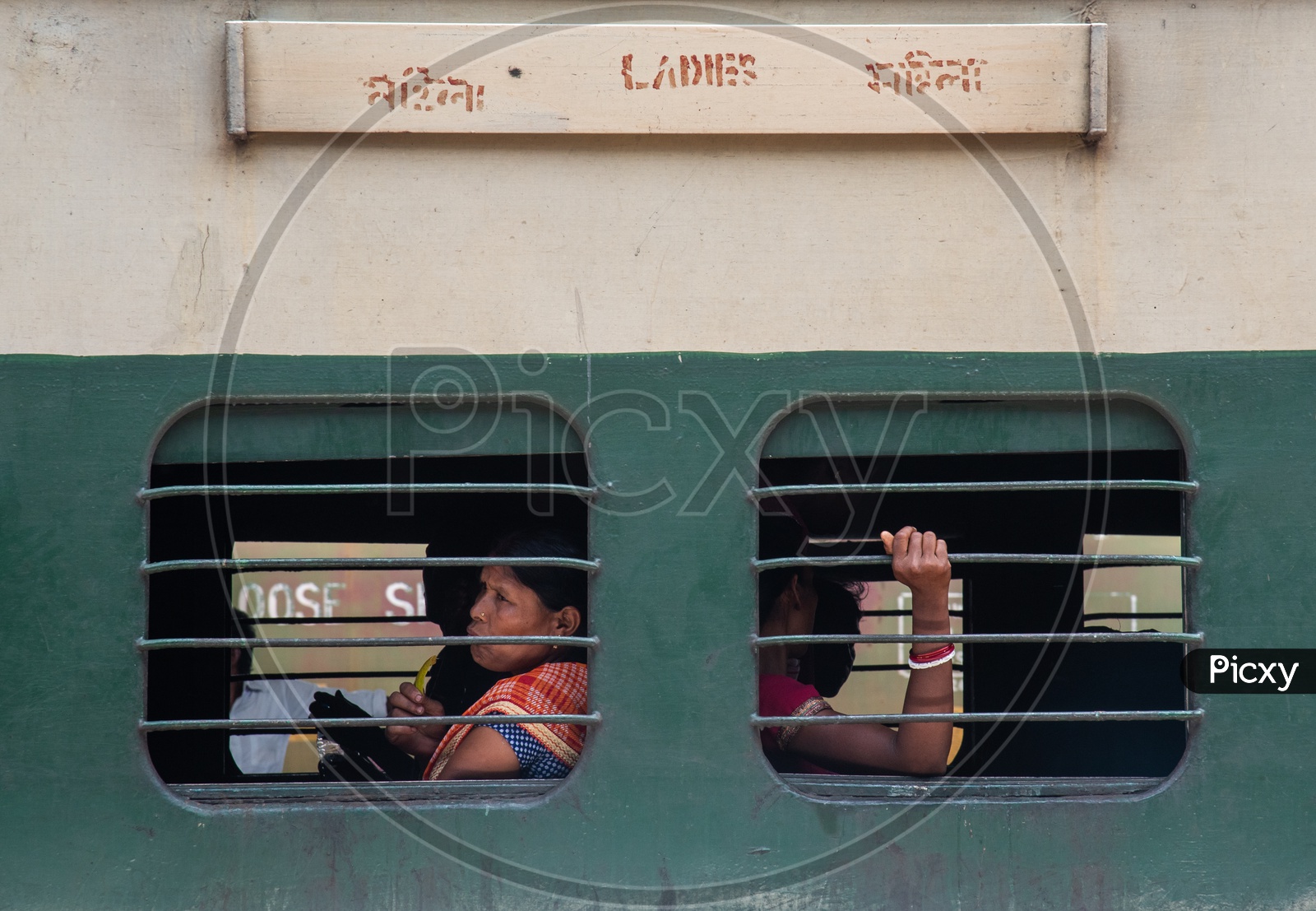 Women Passengers Sitting At a Window Seat In Ladies Compartment Bogie  Of  Indian Railways Train