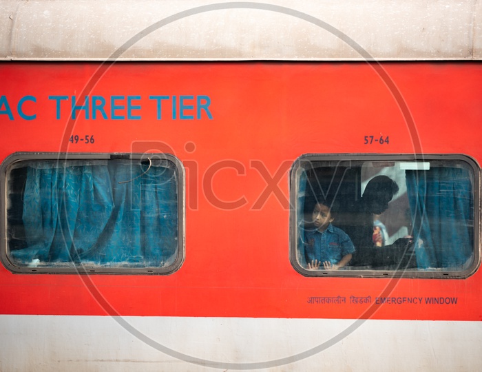 A Kid Or Boy or Child  Looking Through the Window Glass from  a AC Three tier  Bogie of Indian railways Train