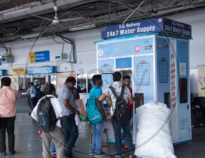 Passengers Filling  Water Bottles At The  Water Supply Points Or Machines By The Indian Railways In a  Railway Station Platform