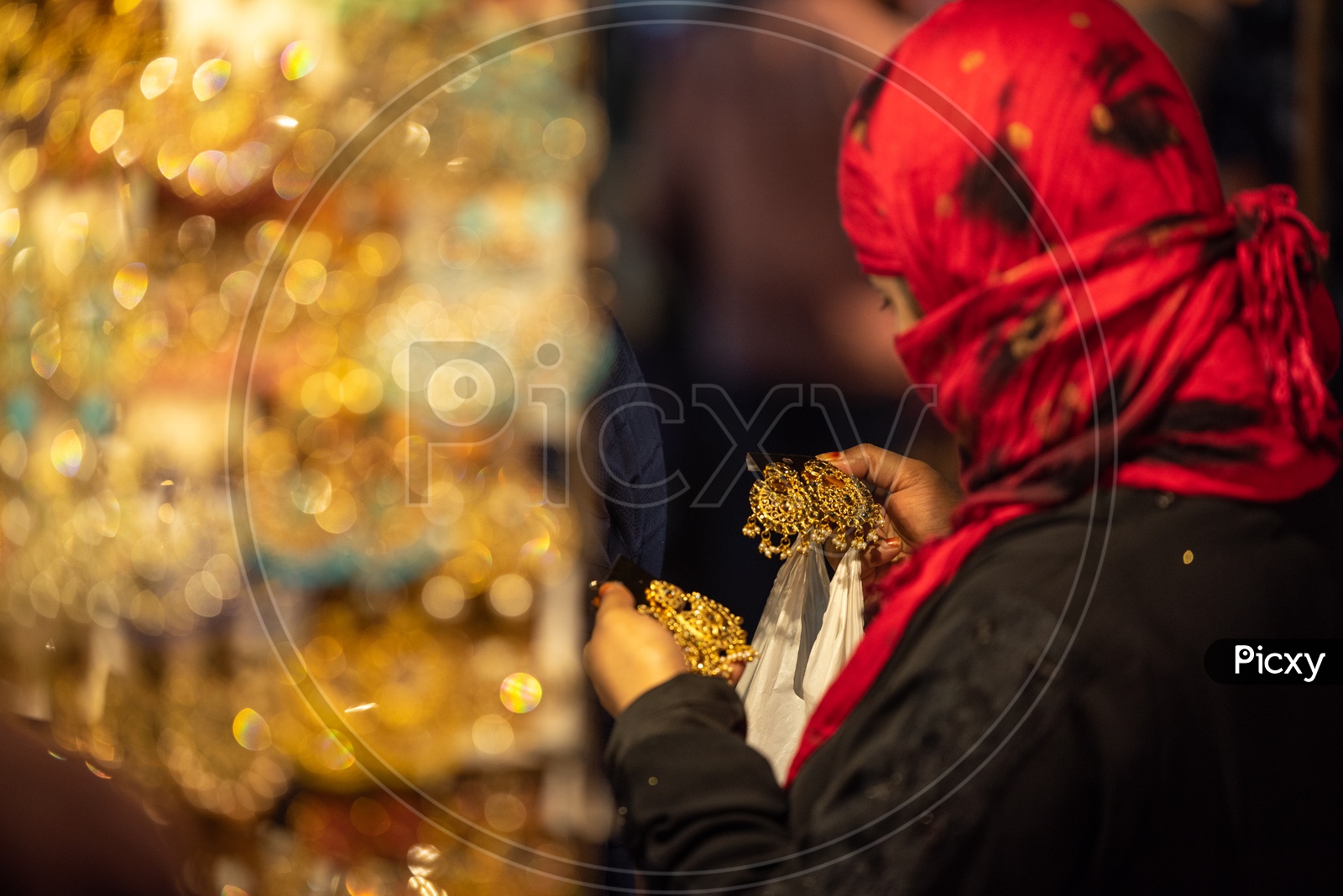 A Muslim Girl In Burkha  Shopping Imitation jewellery Or  Bangles or Ear Rings  At a Vendor Stall Around Charminar Streets  During Ramzan or ramadan Season