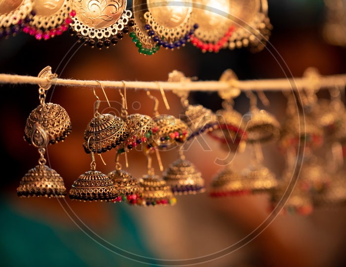 Golden Eartops or  Ear rings Or Imitation Jewellery Hanging  For  Display   In a Vendor Stall  Around Charminar Streets  During  Ramdan Or Ramzan  Season