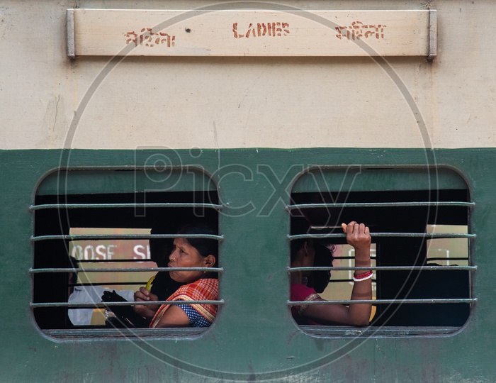 Women Passengers Sitting At a Window Seat In Ladies Compartment Bogie  Of  Indian Railways Train