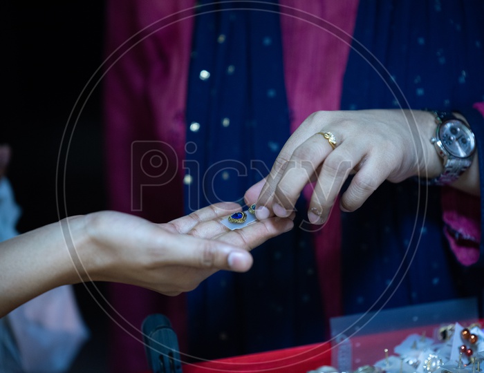 A Woman  Buying or Shopping  Ear Rings or Ear tops  Or Imitation Jewellery  In Vendor Stalls Around Charminar Streets   During Ramadan Or Ramzan Season