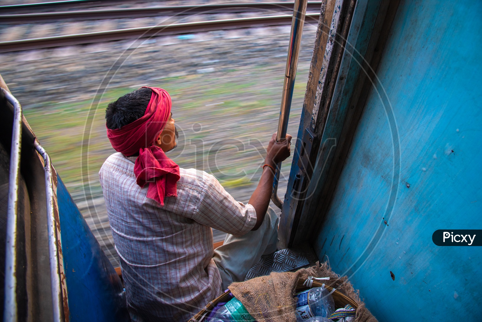 A Rag Picker In Indian Train Sitting at a Door Step While train  Moving